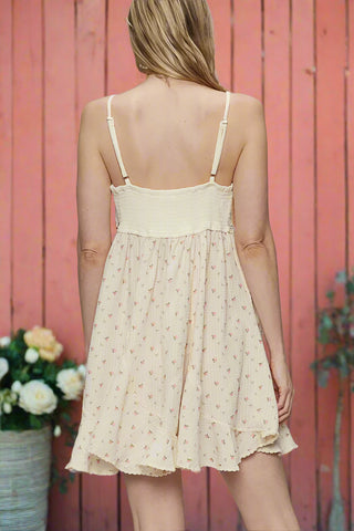 Back view of cream mini dress with adjustable straps and shirred panel