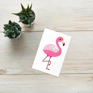 Pink Flamingo Greeting Card on a white table with green plant – envelope included