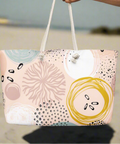 Abstract print tote bag with rope handles held by woman at the beach
