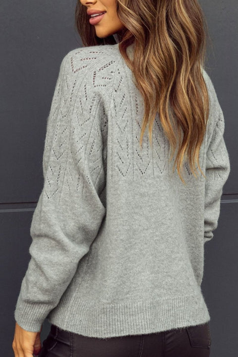 Back detail of a gray openwork cardigan showing intricate knit patterns.