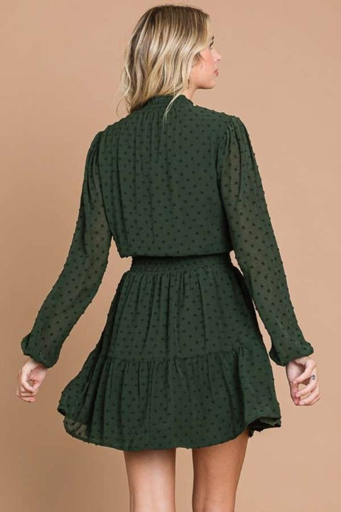 Back view of the green Swiss dot smock neck mini dress with a tiered flowy design