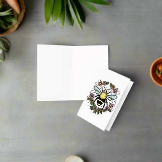 Eco-friendly greeting card featuring a bee inside a floral wreath on premium paperboard on counter