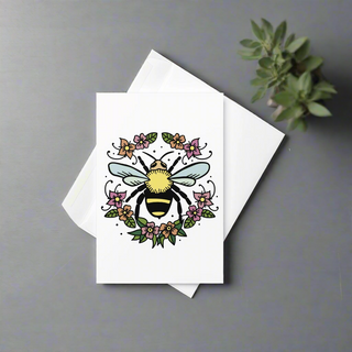 Bee and floral wreath greeting card displayed with white envelope