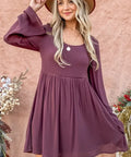 Woman styling bell sleeve dress with boots and wide-brim hat