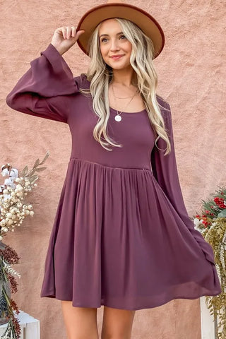 Woman styling bell sleeve dress with boots and wide-brim hat