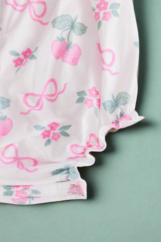 Pink berry & bow print baby romper with ruffle straps, flat lay front
