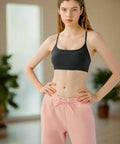 Woman modeling black cami with pink leggings