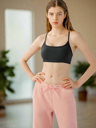 Woman modeling black cami with pink leggings