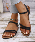 Woman wearing black comfort flat sandals with light wash jeans for a casual summer outfit.