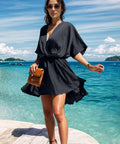 Woman modeling a black mini dress with half sleeves outdoors