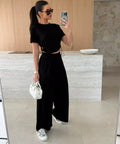 woman wearing black drawstring crop top and wide leg pants matching set