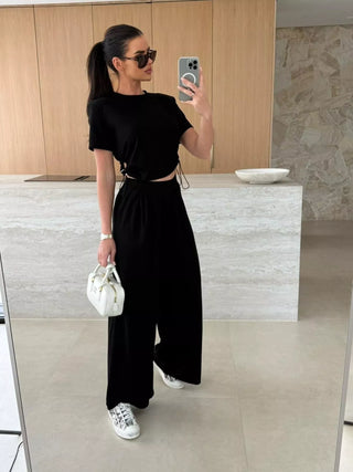 woman wearing black drawstring crop top and wide leg pants matching set