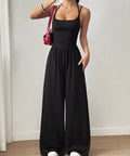 Women's black spaghetti strap wide leg jumpsuit styled for brunch, vacations, and casual summer outfits.