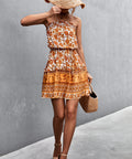 Woman in orange boho mini dress walking away with sunhat