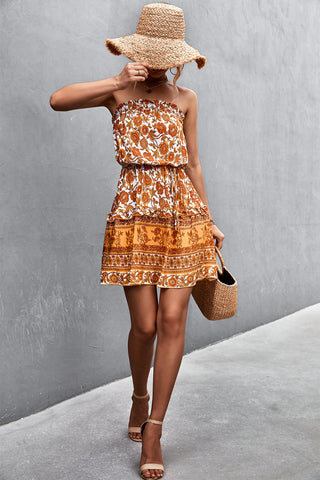 Woman in orange boho mini dress walking away with sunhat