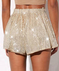 woman wearing champagne sequin high waist shorts with crop top for evening event