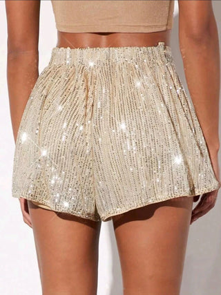 woman wearing champagne sequin high waist shorts with crop top for evening event