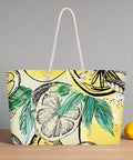 Front view of oversized weekender tote with lemon and leaf print on yellow background, rope handles