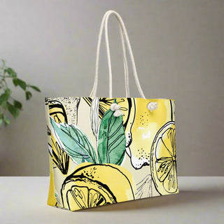 Side angle of lemon and green leaf print tote bag with soft cream rope handles