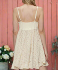 Back view of cream mini dress with adjustable straps and shirred panel