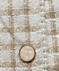 Close-up detail of cream and beige woven plaid textured fabric