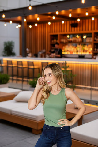 Woman in sage green cropped ribbed tank top, front view