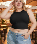 Curvy model wearing black cropped tank top with denim shorts