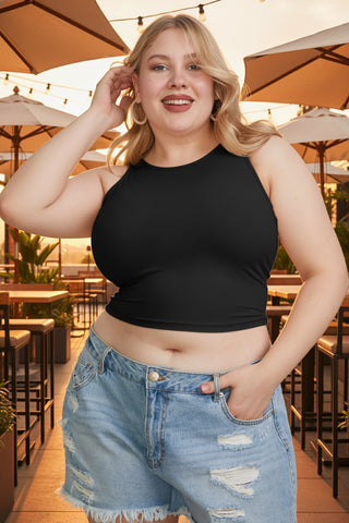 Curvy model wearing black cropped tank top with denim shorts