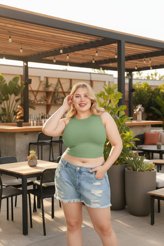 Curvy model in green cropped tank top with denim shorts