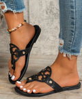 Black cutout slip-on sandals with open toe and circle detail