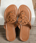 Top view of brown cutout sandals on wood floor