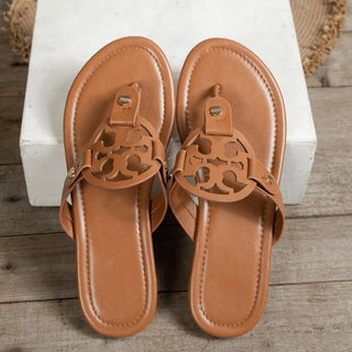 Top view of brown cutout sandals on wood floor