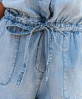 Close-up of drawstring waist and side pockets on denim romper