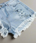 Detailed view of ripped high waist denim shorts with light wash