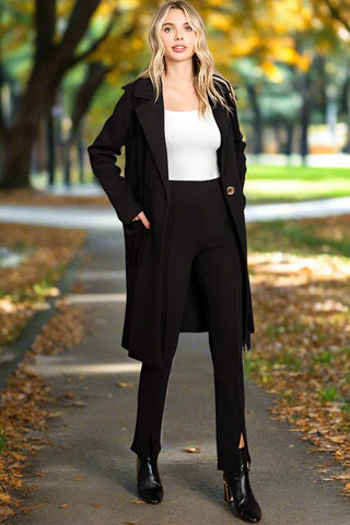 Woman styling longline coat over white top and black pants