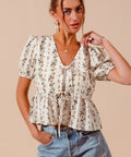Angled view of floral print smocked hem blouse for spring