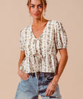 Close-up of floral pattern and smocked hem detail on women’s blouse