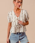 Side profile of floral tie front blouse with stretchy smocked hem