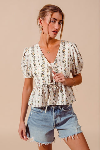 Side profile of floral tie front blouse with stretchy smocked hem