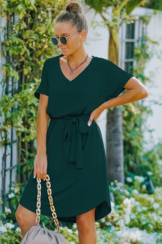 Model wearing green tie-waist mini dress front view 