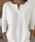 Woman wearing a white half button long sleeve knit top