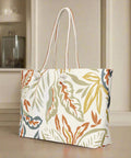 Back angle of fall weekender tote with botanical leaf pattern in orange, olive, and tan