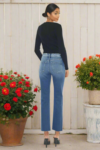 Back view of high rise jeans showing yoke detail and raw hem