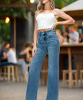 High rise wide leg jeans styled with white top and heels in outdoor setting