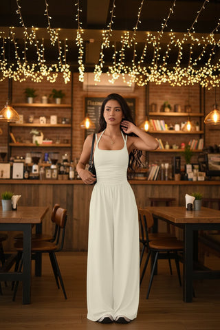 Ivory spaghetti strap wide leg jumpsuit styled for vacations, bridal events, and summer celebrations.