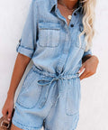 Woman in light denim romper standing casually with hands in pockets