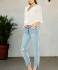 Angled walking pose in distressed boyfriend jeans