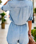 Rear view of short sleeve light wash denim romper with relaxed fit