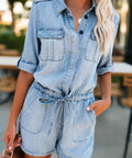 Woman wearing light wash denim romper with drawstring waist and rolled sleeves