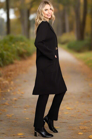 Side view of woman wearing long black trench-style coat
